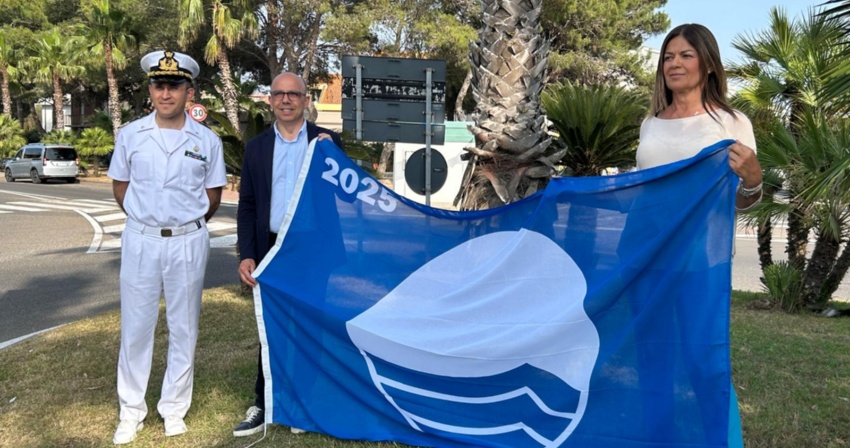 Il Sindaco Sanna, l'Assessore Zedda e il Comandante Chirizzi con la bandiera blu 2025 Il Sindaco Sanna, l'Assessore Zedda e il Comandante Chirizzi con la bandiera blu 2025