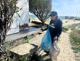 Una volontaria raccoglie rifiuti Una volontaria raccoglie rifiuti