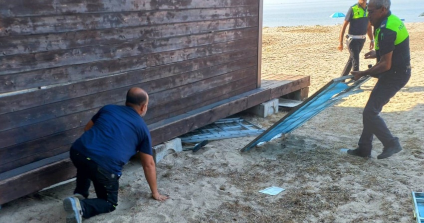 agenti della polizia locale e operai rimuovono il materiale nascosto sotto un chiosco agenti della polizia locale e operai rimuovono il materiale nascosto sotto un chiosco